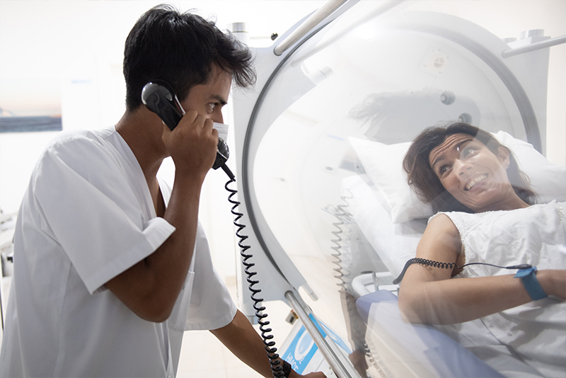 Médico monitorizando a paciente durante sesión de oxigenoterapia hiperbárica en HMCE Estepona
